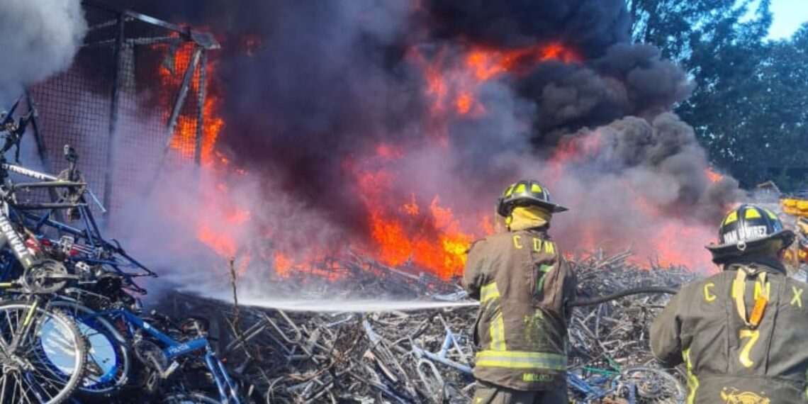 Bomberos atienden fuerte incendio en depósito vehícular en Tláhuac