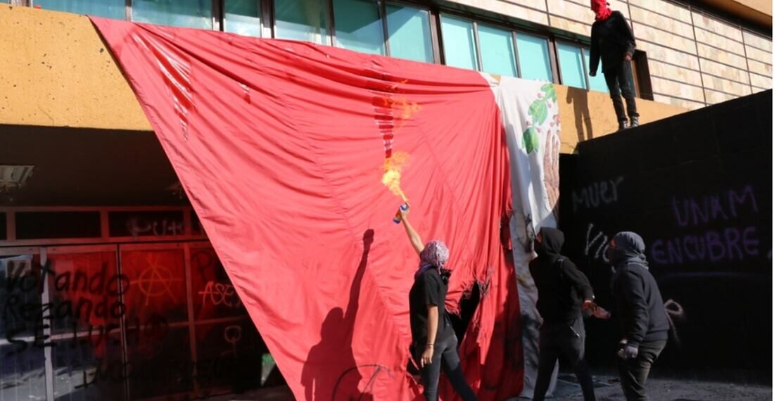 Encapuchados vandalizan UNAM y queman bandera de México